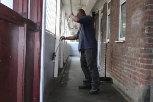 Comment Devenir Gardien D’Immeuble Avec Logement De Fonction 11 gardien dimmeuble devant immeuble residentiel