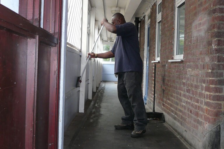 Comment Devenir Gardien D’Immeuble Avec Logement De Fonction 2 gardien dimmeuble devant immeuble residentiel