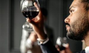 Comment Devenir Commercial en Vin et Spiritueux Avec Succès 31 personne degustant du vin avec enthousiasme