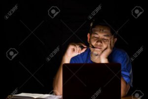 personne reflechissant devant un ordinateur sombre