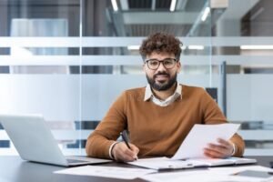 Comment réussir votre demande de transition Pro à Clermont-Ferrand 12 personne souriante avec documents au bureau